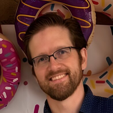 Alan Dipert in front of a wall of giant doughnuts